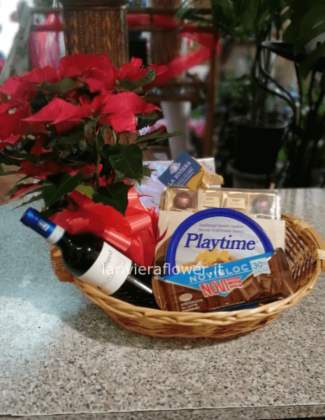 cesto con vari prodotti natalizi come vino e panettone
